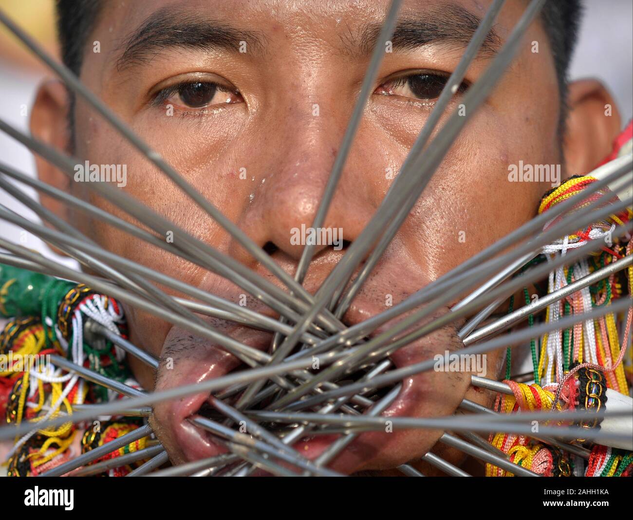 Thai Chinesische taoistische Anhänger (MAH) durchdringt seine Wangen und Lippen mit verzierten Stahl Stifte/Spieße während der Phuket Vegetarian Festival. Stockfoto