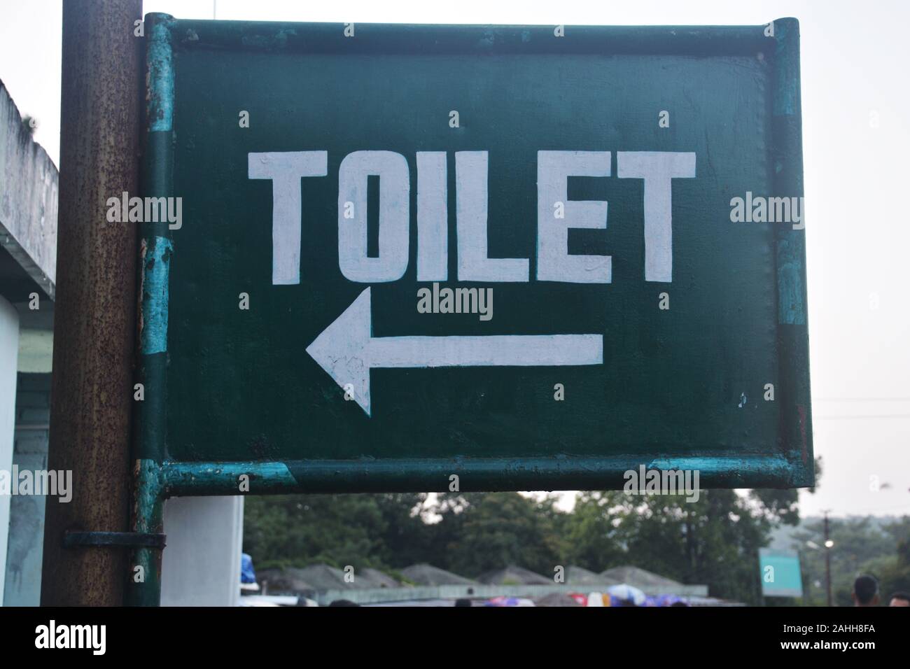Zeichen der Wc in weißer Farbe auf einem Verzinnt mit grüner Farbe Hintergrund auf einem dicken eiserne Leitung fest geschrieben Stockfoto