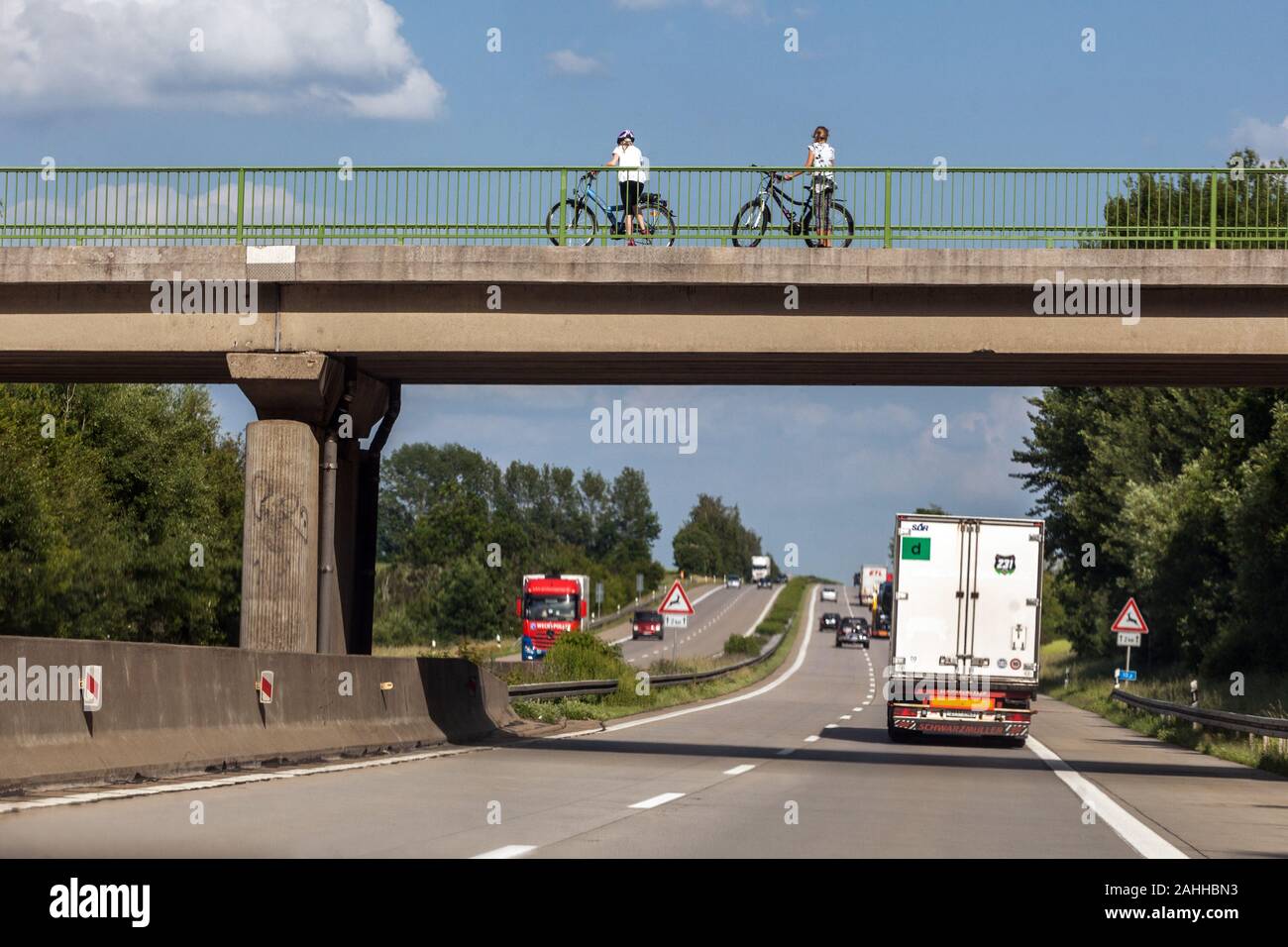 Menschen, zwei Bikerinnen auf der Brücke über die deutsche Autobahn Deutschland Active Lifestyle Radtour, Radfahren auf der Straße Stockfoto