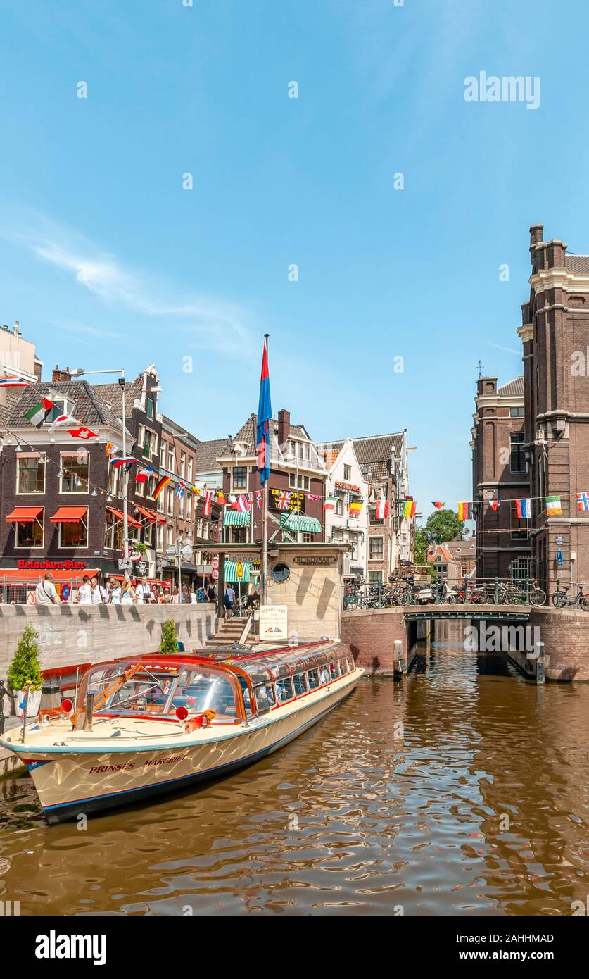 Typische Sightseeing Boote im Wasser Kanal im Zentrum von Amsterdam, Niederlande Stockfoto