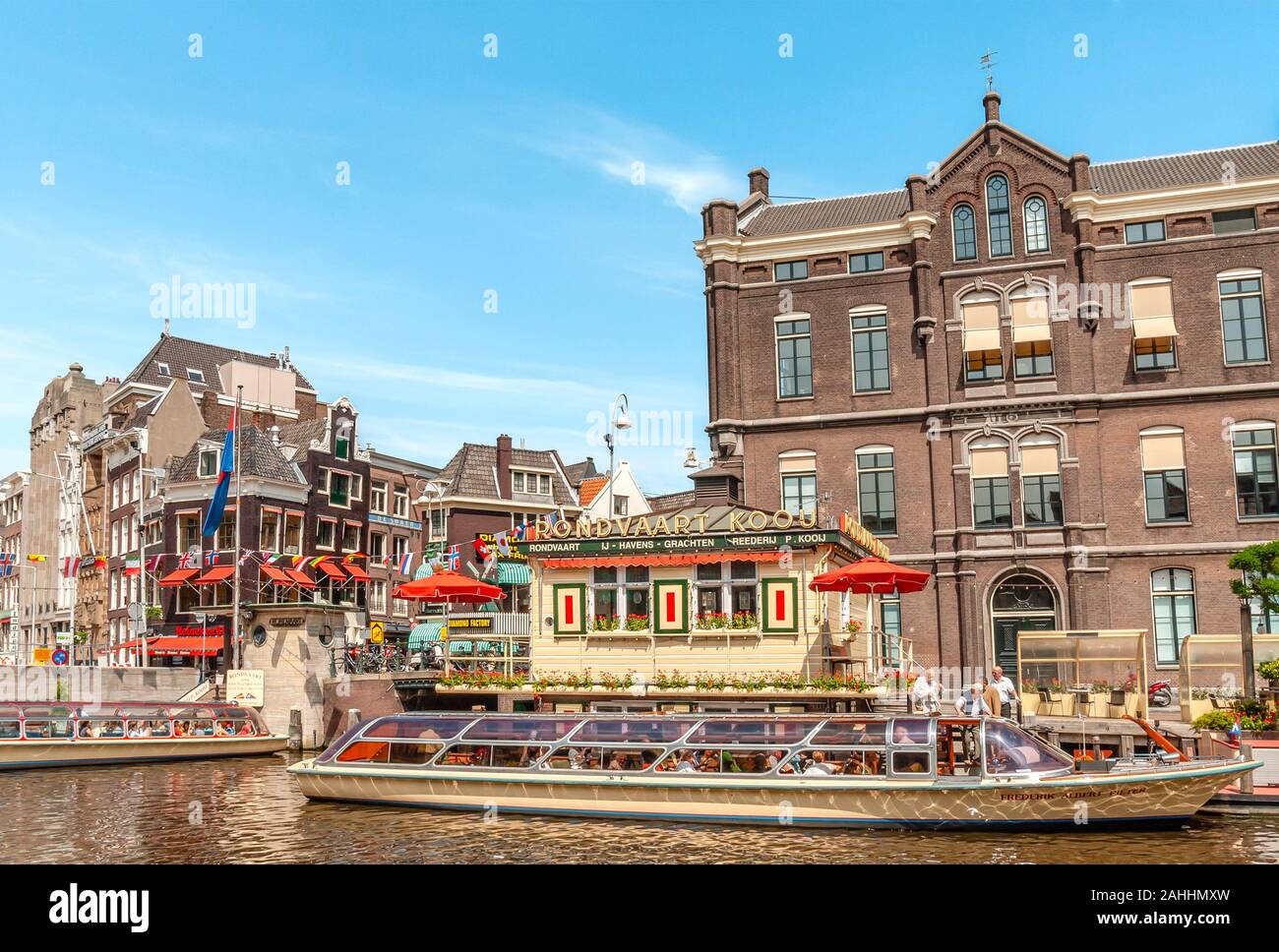 Typische Sightseeing-Boote in einem Wasserkanal in das Stadtzentrum von Amsterdam, Niederlande. Stockfoto