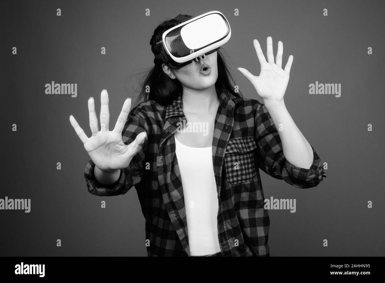 Junge schöne asiatische hipster Frau gegen grauer Hintergrund Stockfoto