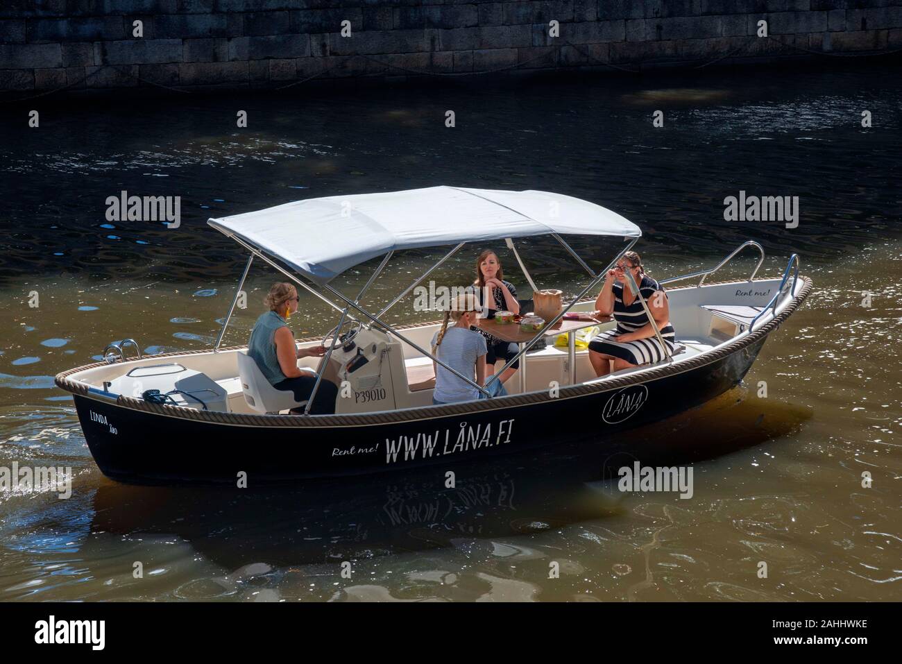 Familie in elektrische Boote zum Mieten im Fluss Aura in Turku, Finnland. Stockfoto