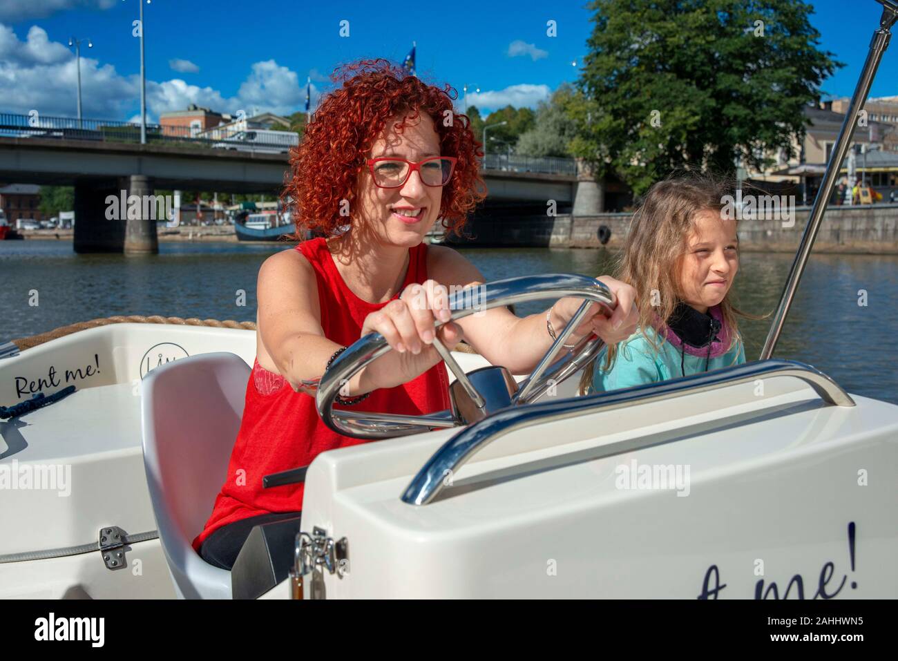 Familie in elektrische Boote zum Mieten im Fluss Aura in Turku, Finnland. Stockfoto
