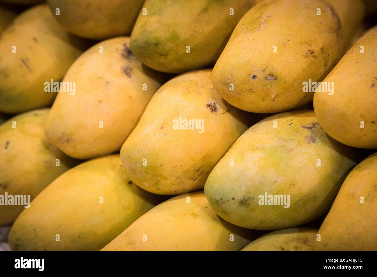 Nahaufnahme Mangos Haufen zusammen haben Muster vor Shop am Markt Stockfoto