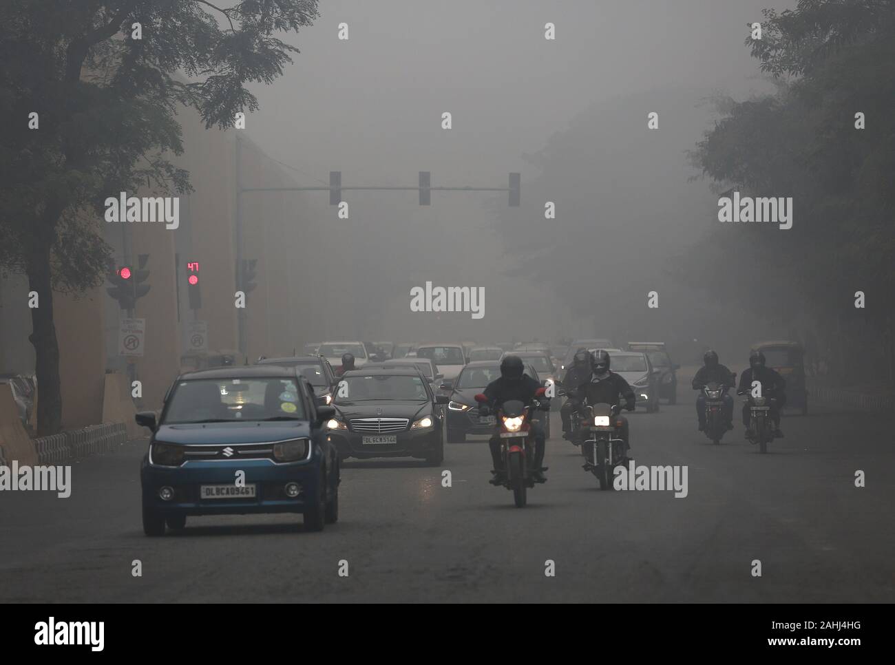 New Delhi. 30 Dez, 2019. Fahrzeuge laufen auf einer Straße inmitten dichter Nebel in Neu Delhi, Dez. 30, 2019. Dichten Decke von Nebel der indischen Hauptstadt Neu Delhi und Stadtrand Montag Morgen bedeckt, die zu Störungen im Luft- und Schienenverkehr, sagten Beamte. Credit: Javed Dar/Xinhua/Alamy leben Nachrichten Stockfoto