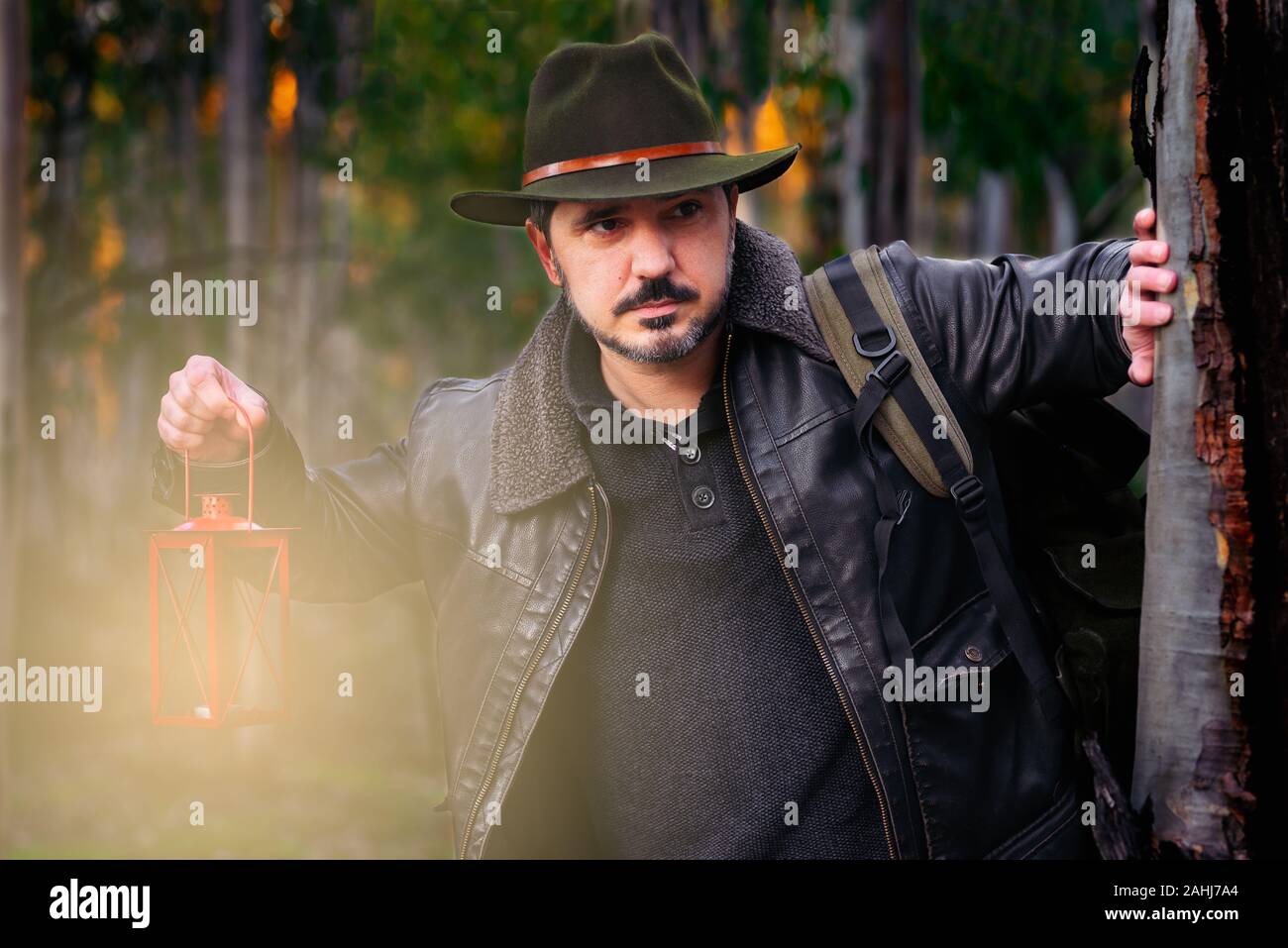 Reifer Mann mit Hut und Jacke mit alte Lampe. Stockfoto