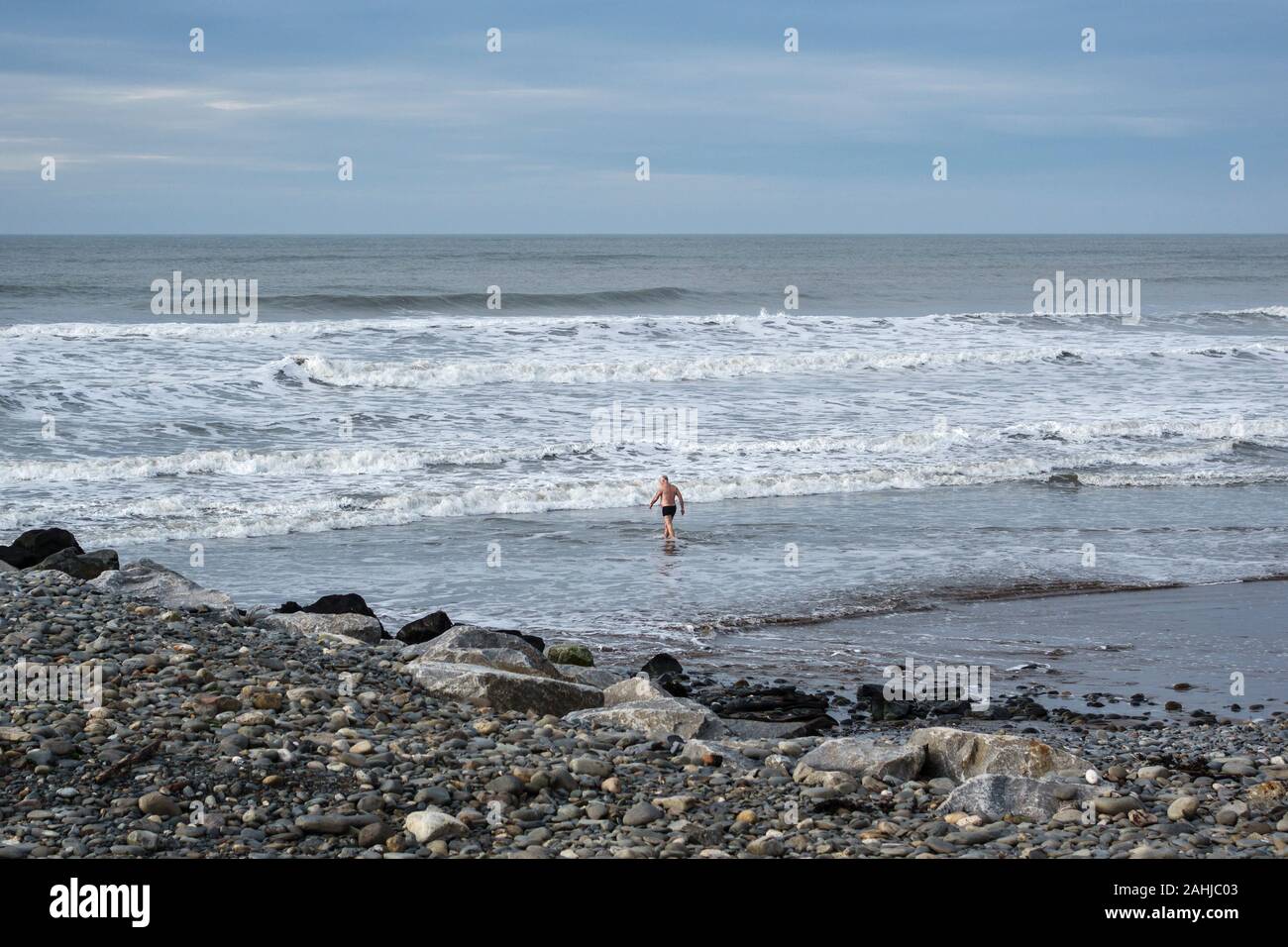 Gleich nach Weihnachten, ein einsamer Schwimmer trotzen einem kalten Winter Meer in Borth, an der walisischen Küste in der Nähe von Arrochar Stockfoto