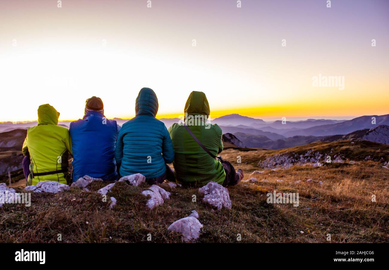 Vier Wanderer auf einem Berg genießen Sie die Aussicht bei Sonnenuntergang Stockfoto