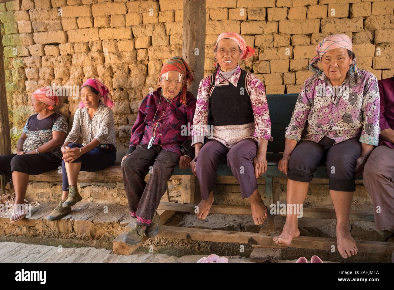 Ältere Frauen von Yi ethnische gruppe Rest in Cangtai Dorf mit traditionellen irdenen Wohnungen - tuzhangfang, Honghe, Yunnan, China. Stockfoto