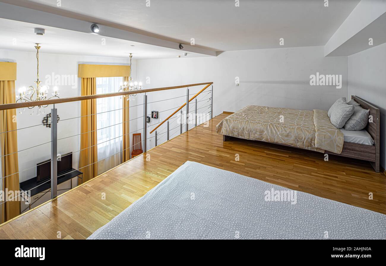 Zwei Betten auf der zweiten Etage im eigenen Haus. Moderne Einrichtung in hellen Farbtönen. Weiße Wände. Stockfoto