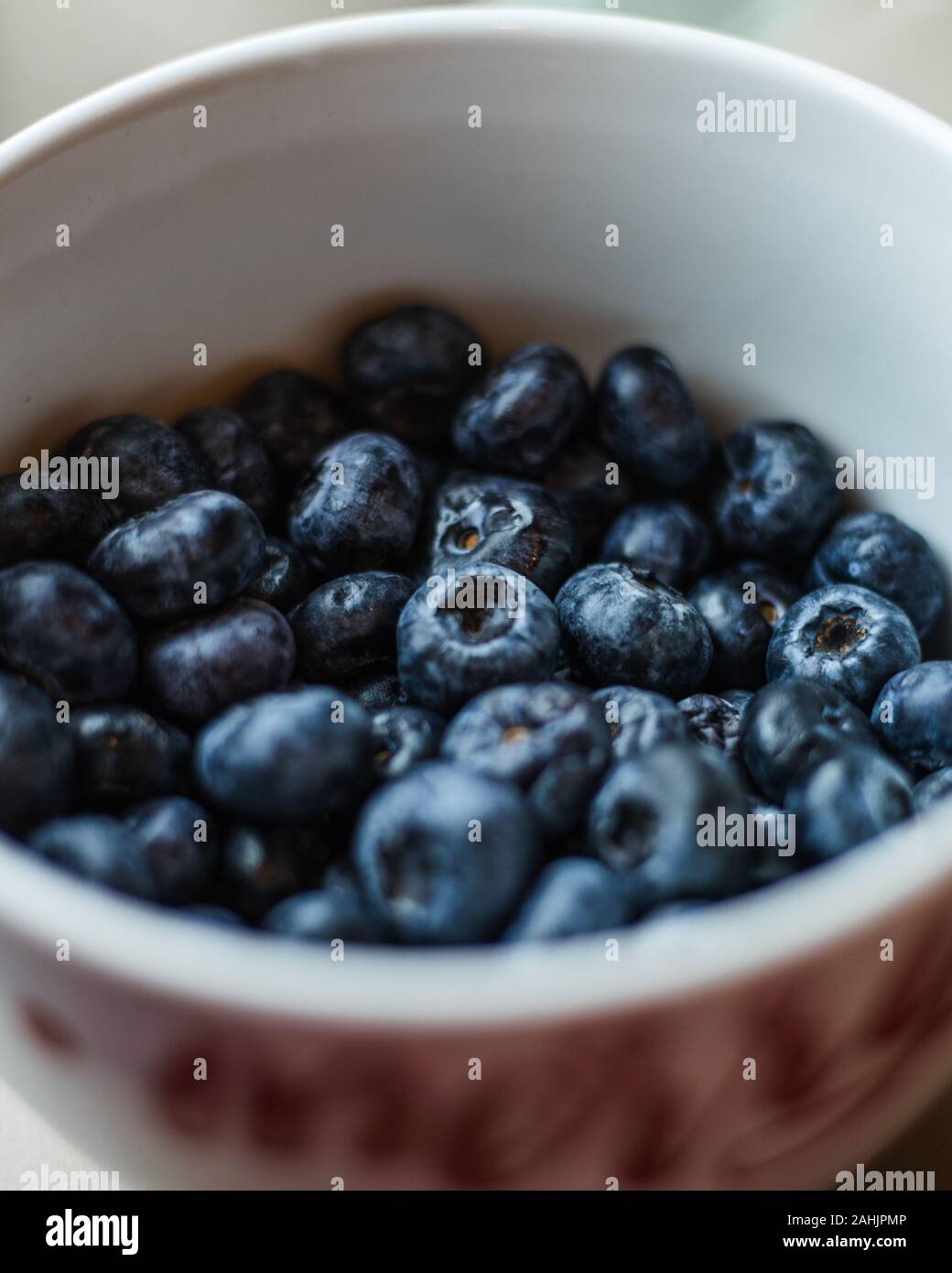 Frisch gewaschene Feucht Blaubeeren in weiße Schüssel mit einer geringen Tiefenschärfe/verschwommenen Hintergrund Stockfoto