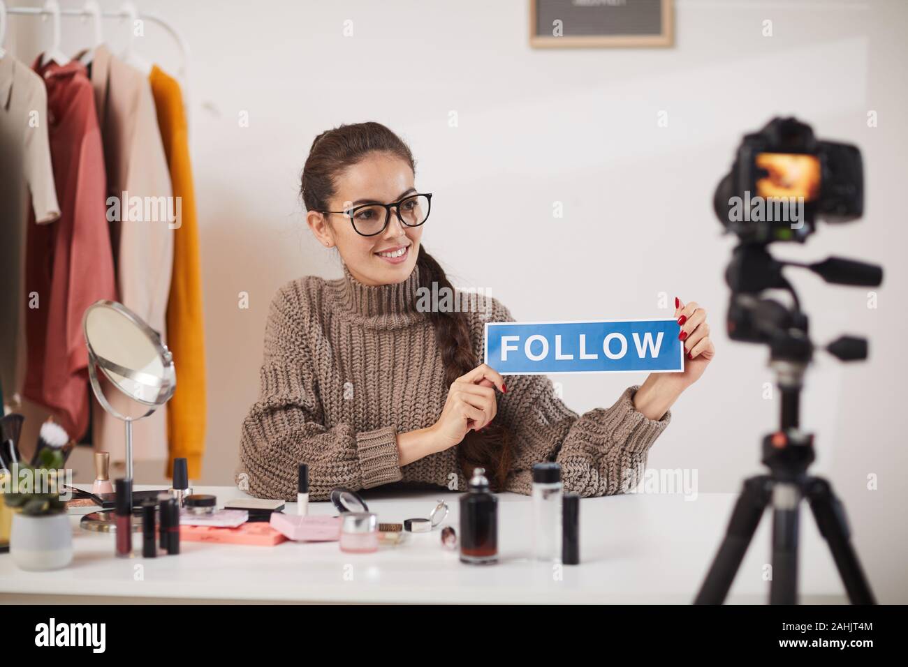 Porträt des zeitgenössischen junge Frau mit Wort folgen, während Dreharbeiten video für Beauty und Lifestyle channel, kopieren Raum Stockfoto
