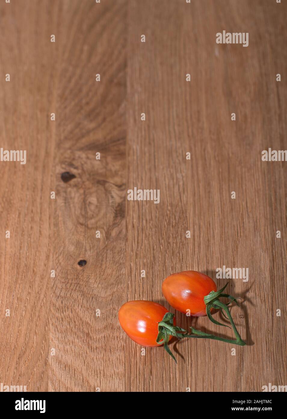 Red Cherry Strauchtomaten auf hölzernen Tisch Stockfoto