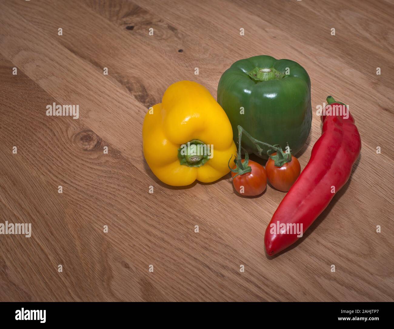 Red Cherry Strauchtomaten auf hölzernen Tisch Stockfoto