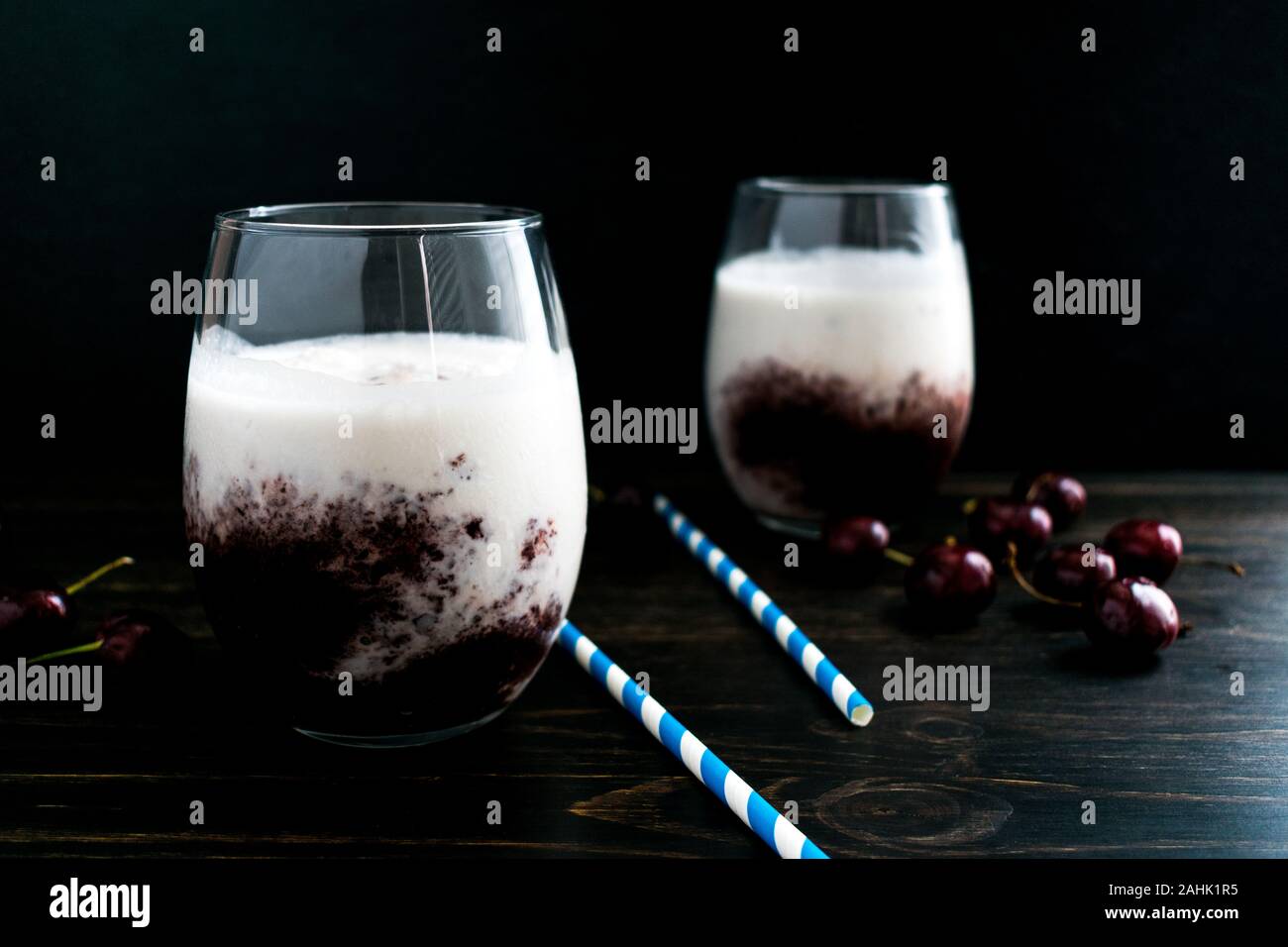 Frische Kirsche Smoothies mit Papier Trinkhalme: Zwei Smoothies mit Kokosmilch und kirschpüree in stemless Weingläser gemacht Stockfoto
