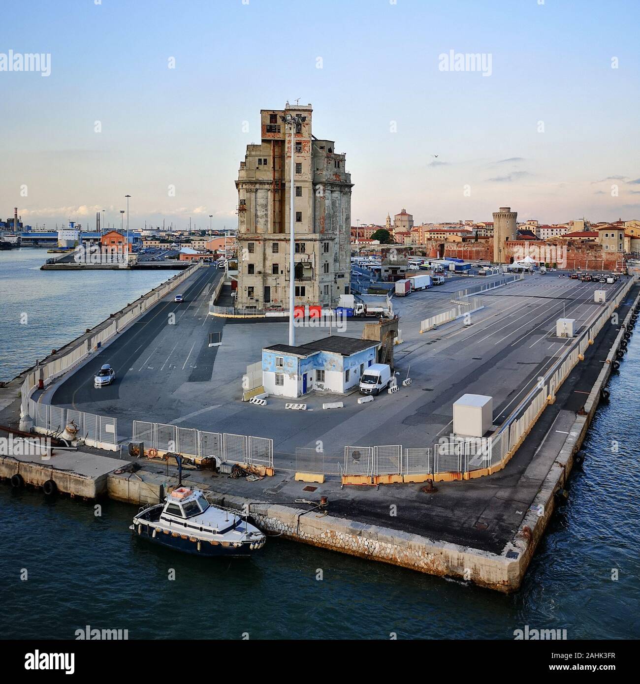 Blick auf den Kai der Hafen von Livorno bei Sonnenuntergang. Verlassene Gebäude. Industrielle Archäologie. Stockfoto