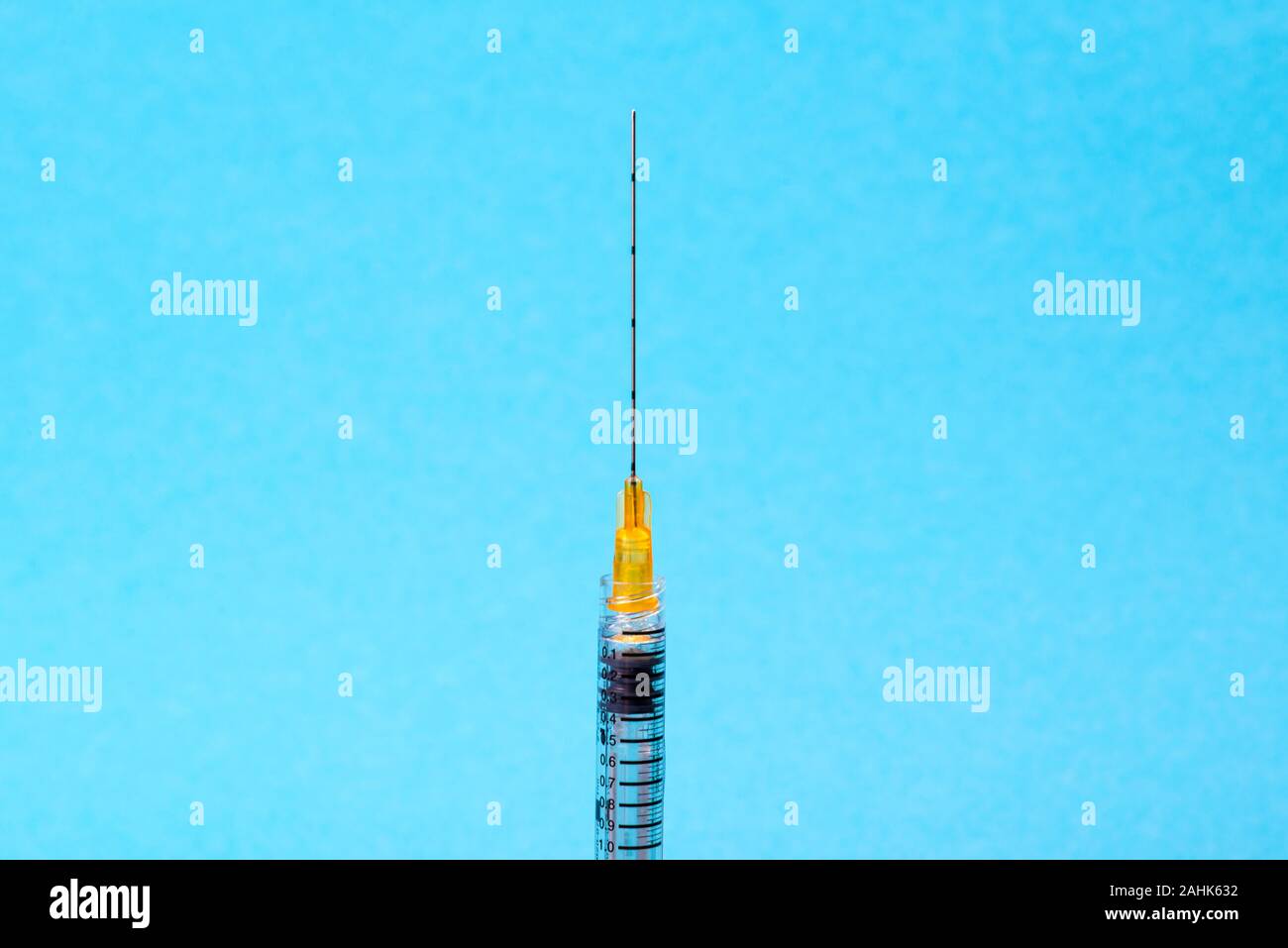 Medizinische Kunststoff Spritze mit Nadel für Schönheit Injektionen auf blauem Hintergrund. Therapie Konzept. Selektiver Fokus Stockfoto