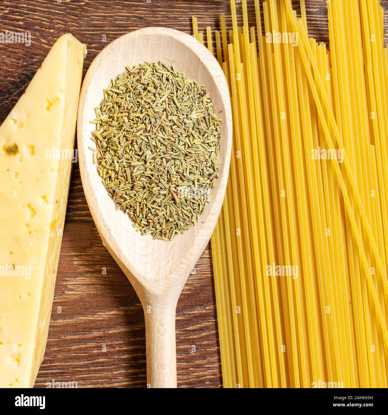Pasta und Käse neben einem Löffel mit Gewürzen Stockfoto