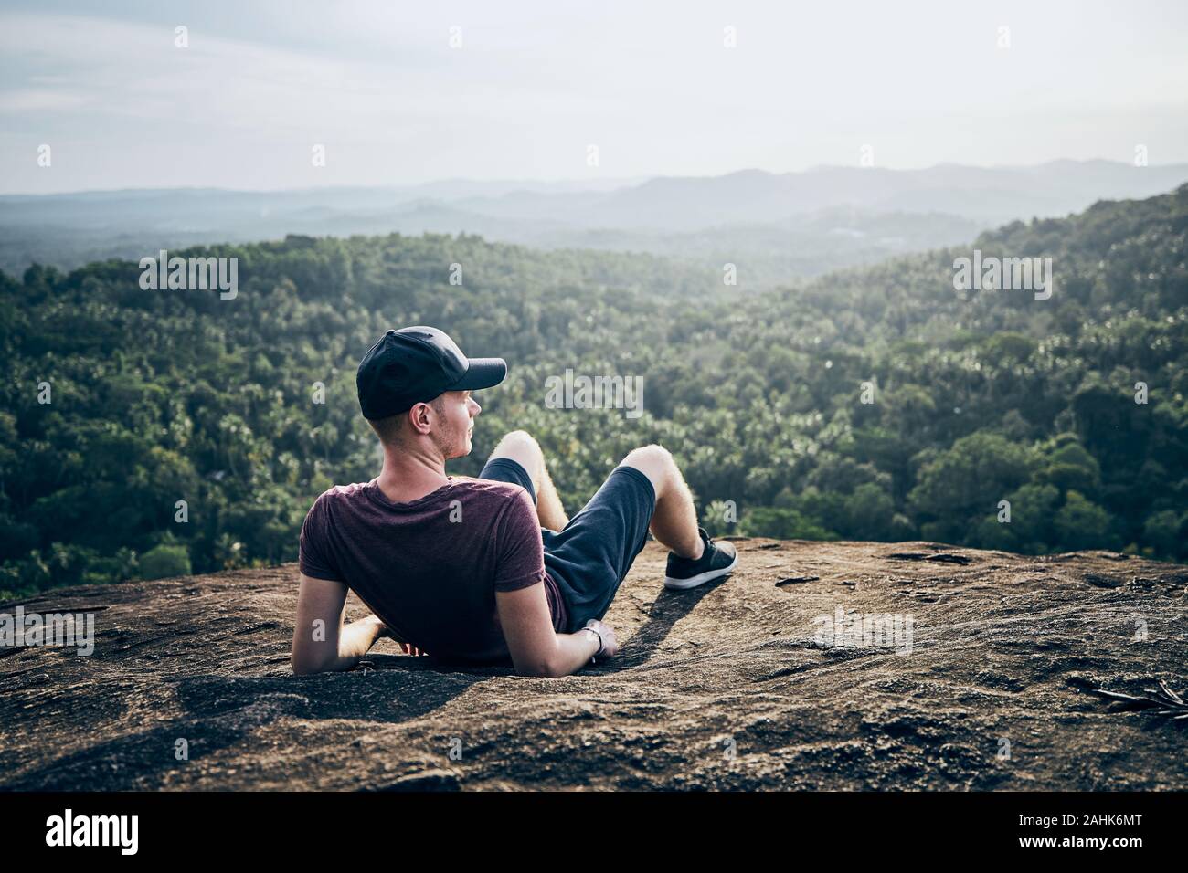 Nachdenkliche Menschen, die auf der Oberseite von Rock über Dschungel. Landschaft mit Palmen in Sri Lanka. Stockfoto