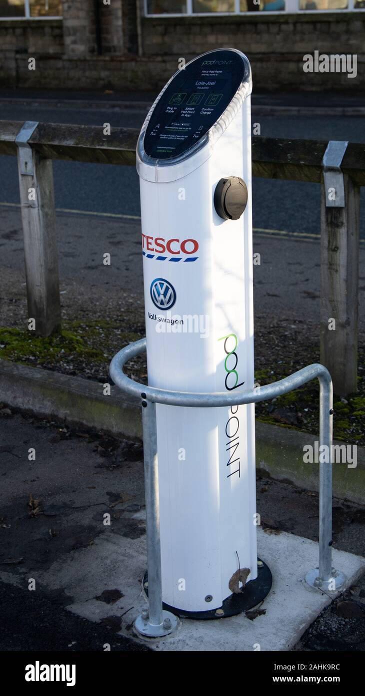 Ein elektrisches Auto aufladen podpoint Warten an einem Tesco Stores in Greenfield, Oldham, Großbritannien beauftragt zu werden. Stockfoto