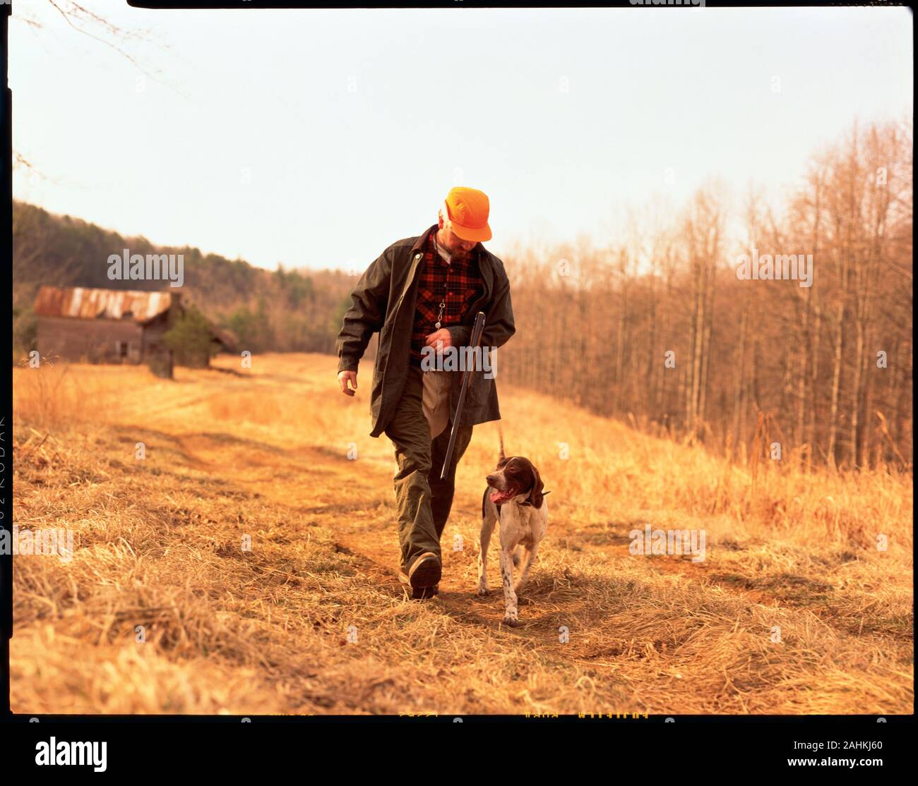 Vorderansicht eines Mannes, der auf der Jagd nach Spiel mit seinem Hund. Stockfoto