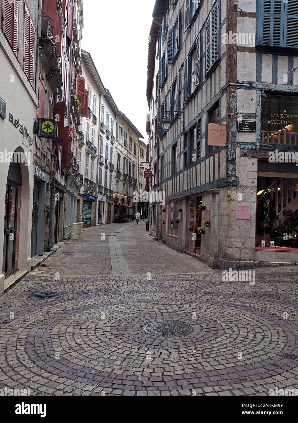 Kreisförmige gemusterte Steinpflasterung an einer Kreuzung mit der Rue du Pilori im alten Einkaufsviertel der alten baskischen Stadt Bayonne, Frankreich Stockfoto