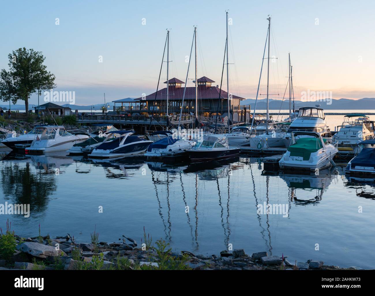 Dämmerszene des Lake Champlain Docks in Burlington, Vermont, mit im Vordergrund angedockten Booten in der Nähe des Burlington Centers. Stockfoto