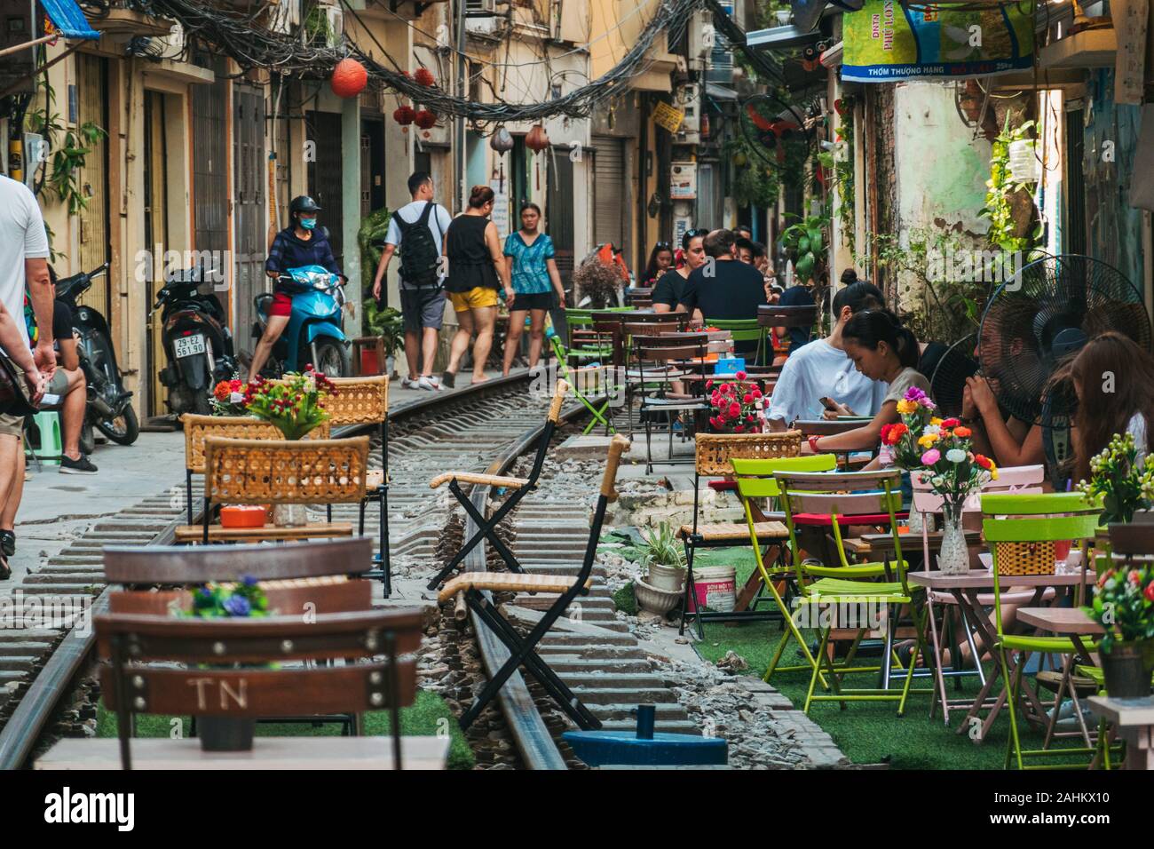Touristen genießen Café im Freien Sitzplätze auf der Tracks in Hanoi die unbeliebten Zug Straße, Ngo 224 Le Duan, in der Altstadt. Stockfoto