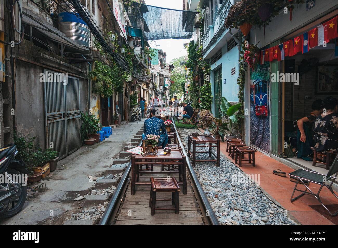 Touristen genießen Café im Freien Sitzplätze auf der Tracks in Hanoi die unbeliebten Zug Straße, Ngo 224 Le Duan, in der Altstadt. Stockfoto