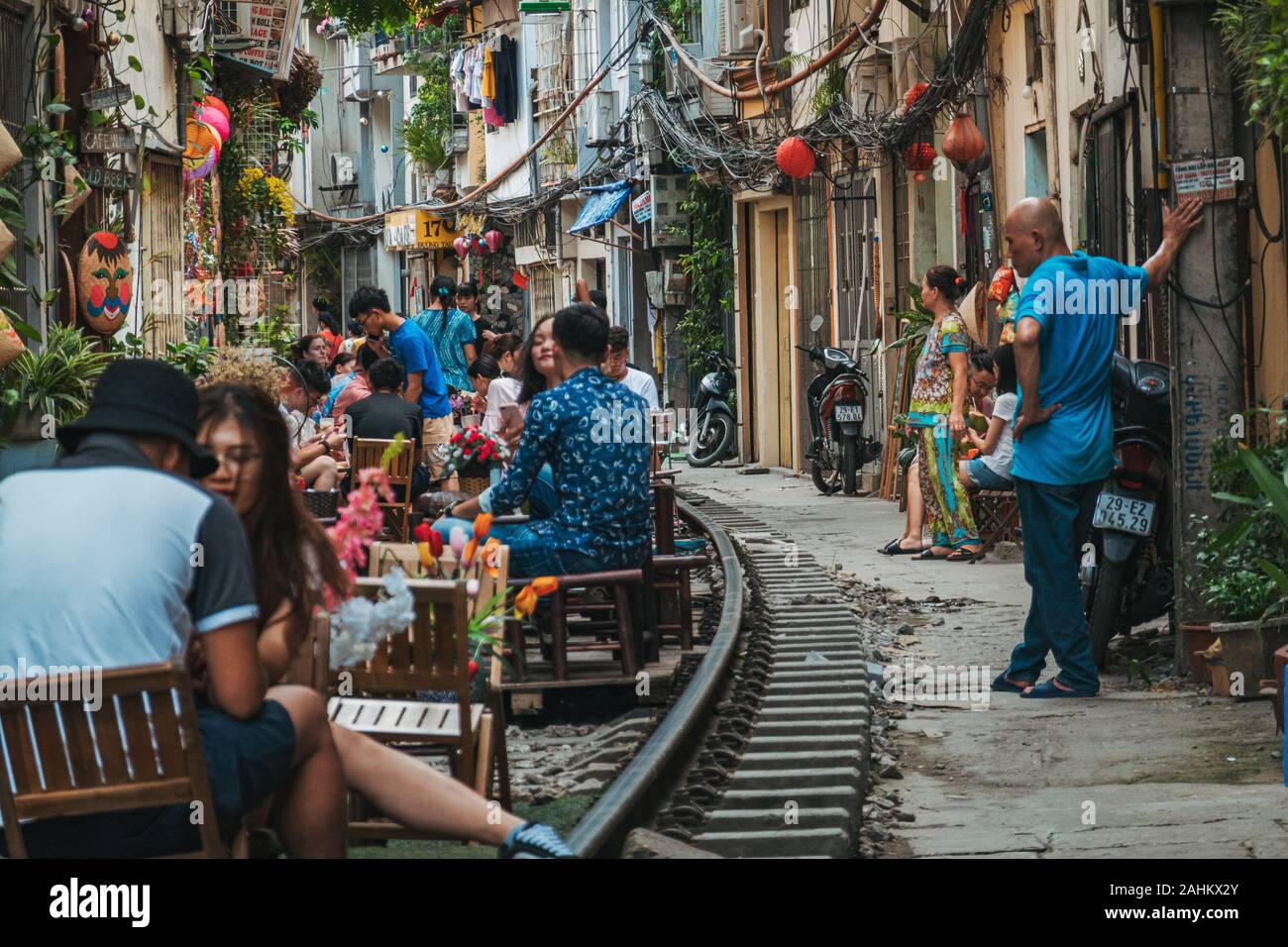 Touristen genießen Café im Freien Sitzplätze auf der Tracks in Hanoi die unbeliebten Zug Straße, Ngo 224 Le Duan, in der Altstadt. Stockfoto