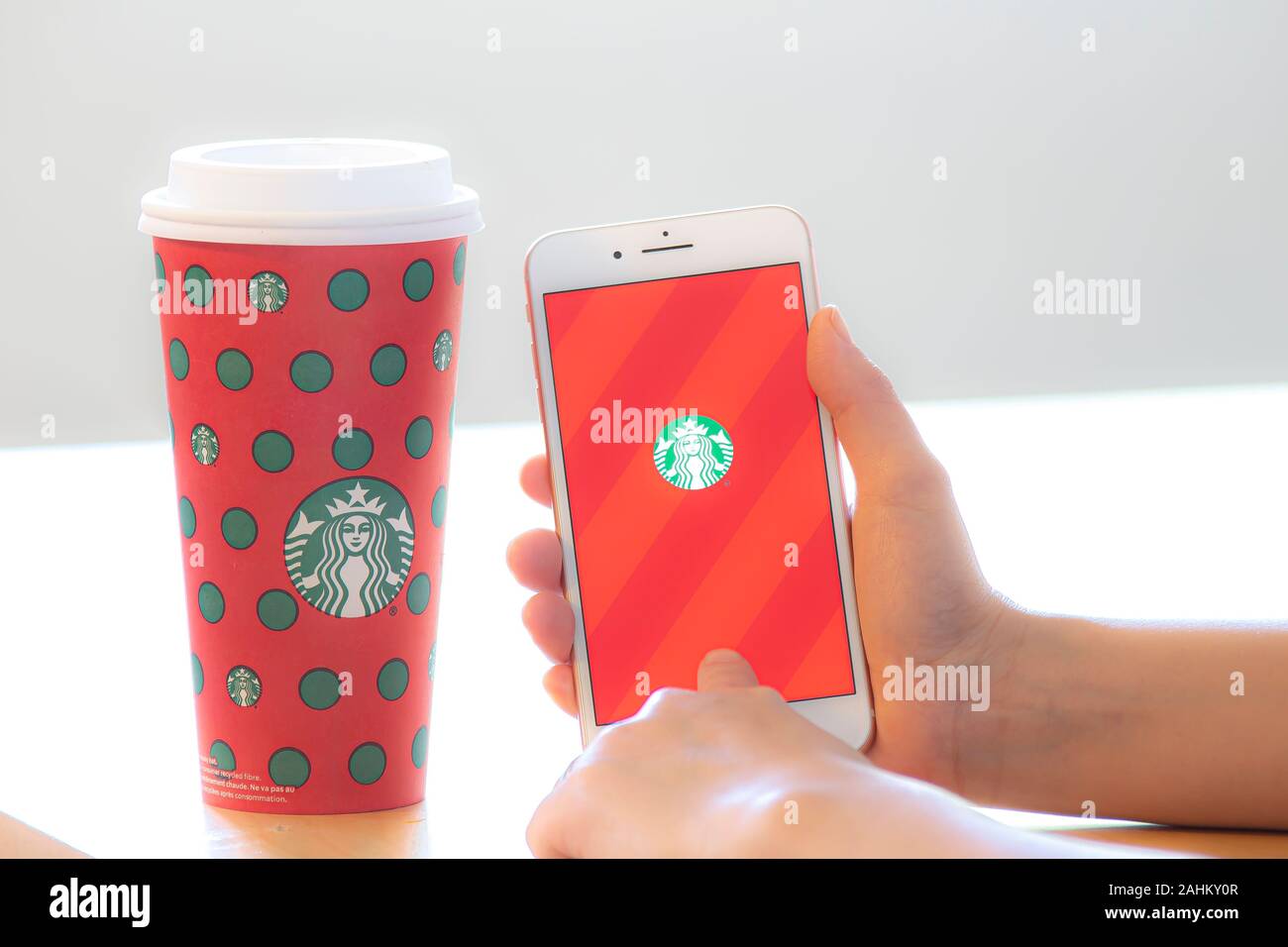 Calgary, Alberta. Kanada 28.Dezember 2019. Eine Person, die ein mit dem iPhone App mit einem Starbucks Kaffee während Weihnachten. Starbucks hat Mitarbeiter gefeuert Stockfoto