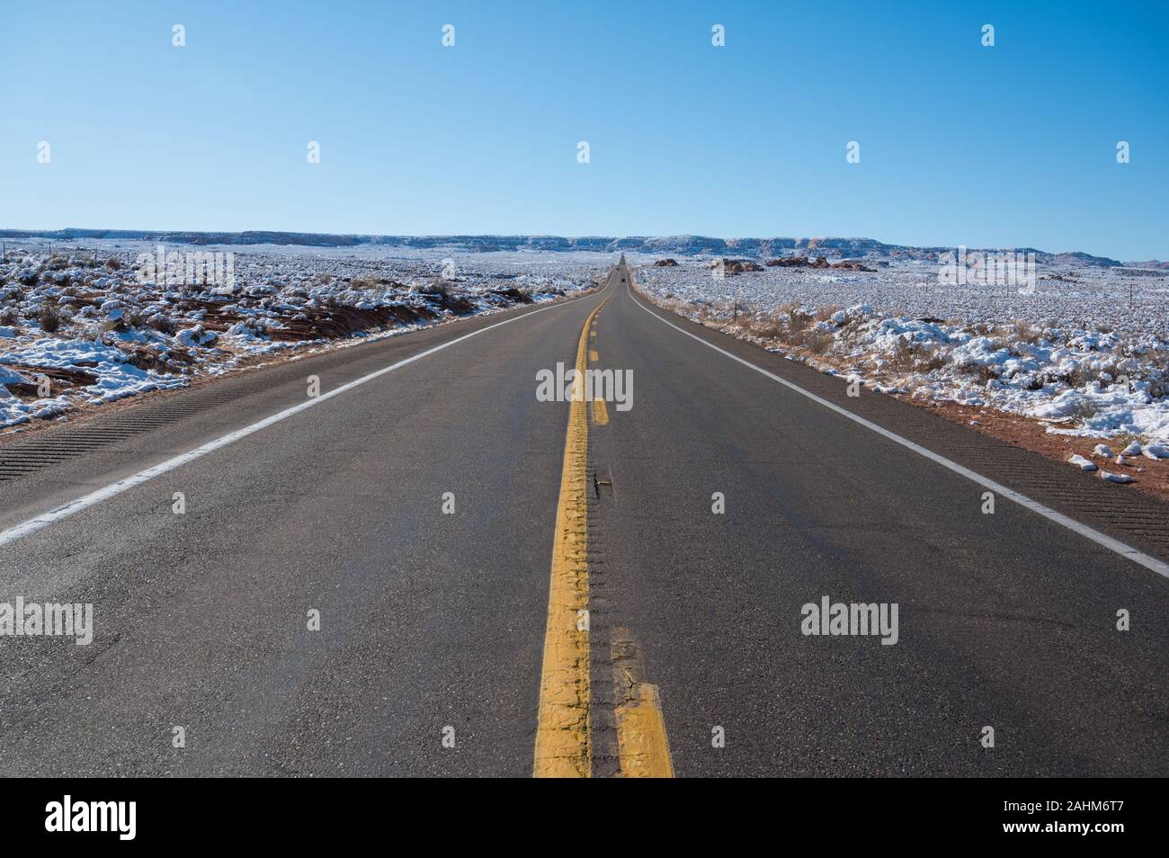 Asphaltierte Straße durch die verschneite Winterlandschaft in Arizona Stockfoto