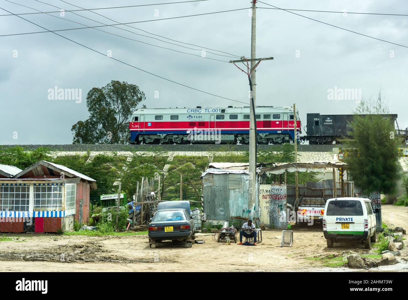 Ein DF8B Diesel lok Güterzug vorbei an Hütten auf der SGR-standard Gauge Railway, Kenia Stockfoto