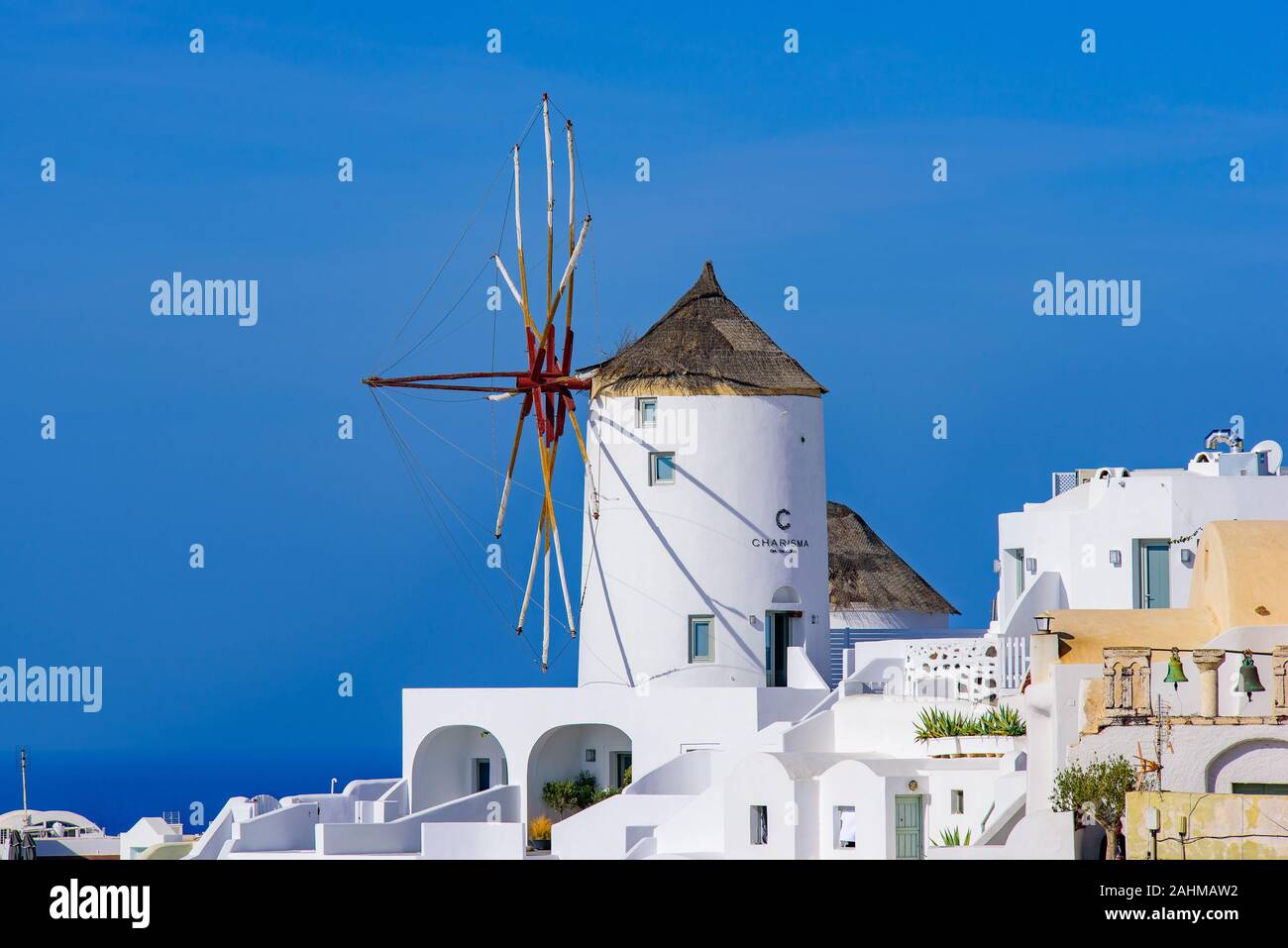 Windmühle und traditionelles weißes Gebäude mit Blick auf das Mittelmeer in Oia, Santorini, Griechenland Stockfoto