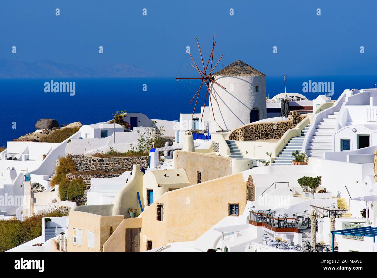 Windmühle und traditionelles weißes Gebäude mit Blick auf das Mittelmeer in Oia, Santorini, Griechenland Stockfoto