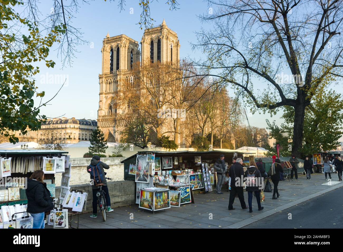 Reihen der Stände auf den Quai de Montebello verkaufen Kunstwerke, Geschenke und Souvenirs als Menschen gehen vorbei und Cathédrale Notre-Dame de Paris im Hintergrund, Paris, Stockfoto