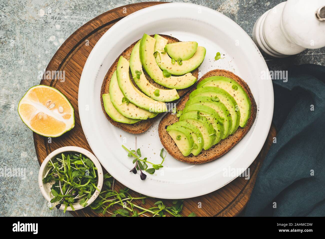 Roggen Brot Toast mit Avocado- und Micro grün sprießt. Ansicht von oben. Sauber Essen, gesundes Essen Konzept. Getonten Bild Stockfoto