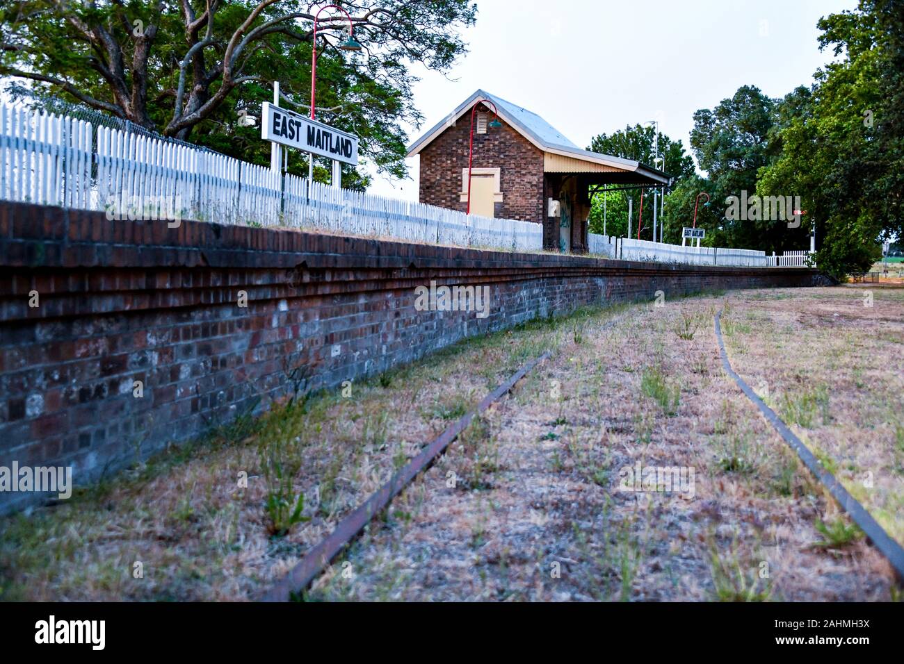 Aufgabe der früheren East Maitland Station und Plattform auf der die Verstorbene Morpeth Strangleitung mit Lattenzaun, Beschilderung, Beleuchtung und Signal im Hintergrund Stockfoto