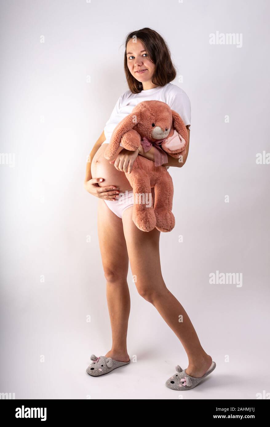 Close-up schwangeren Bauch mit Hase Spielzeug. Schöne schwangere Frau. Schwangerschaft, Elternschaft, Vorbereitung und Erwartung Konzept. Stockfoto