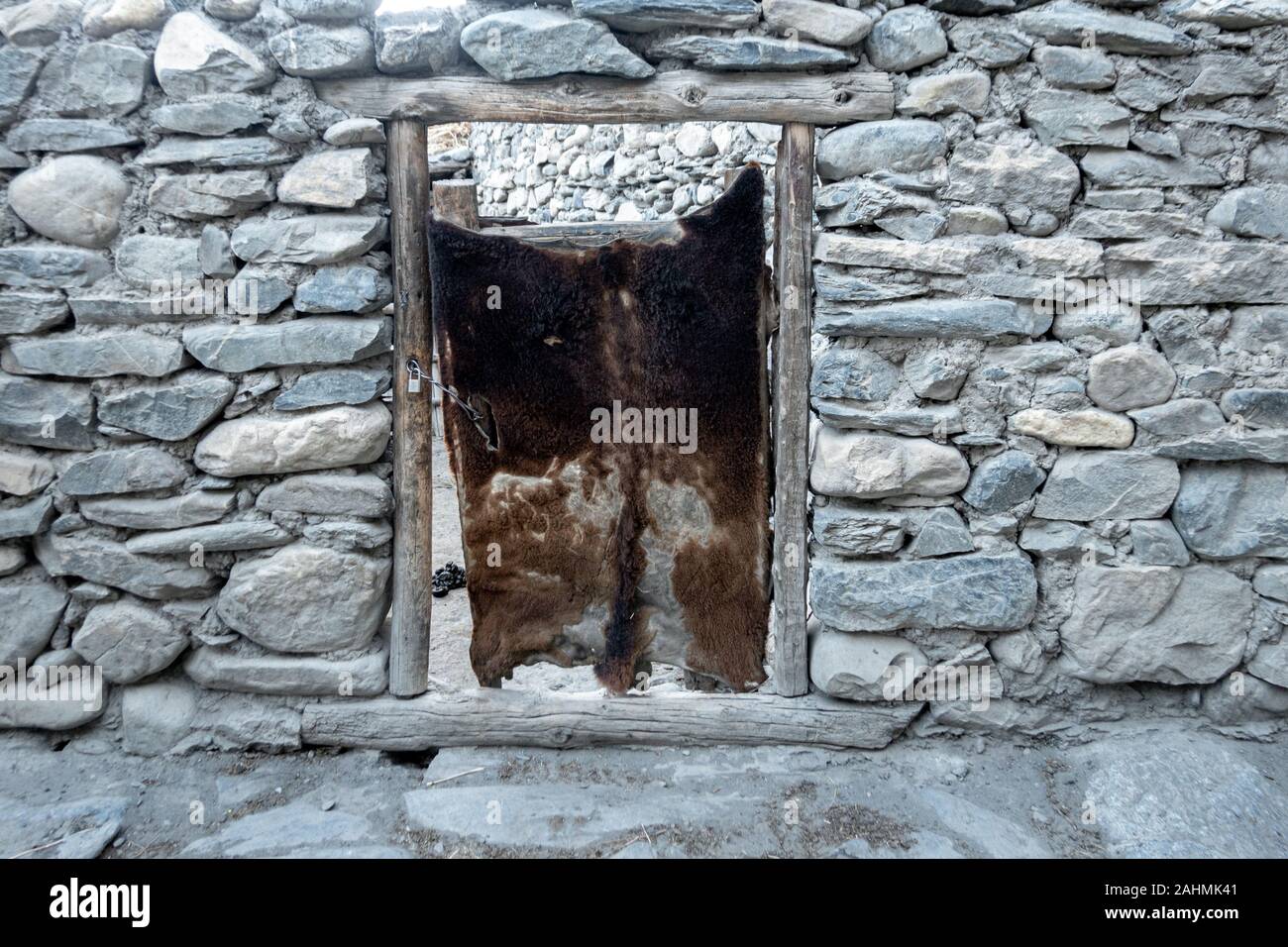 Eine Tür, die mit einem Tier in eine Mauer aus Stein verstecken. Stockfoto
