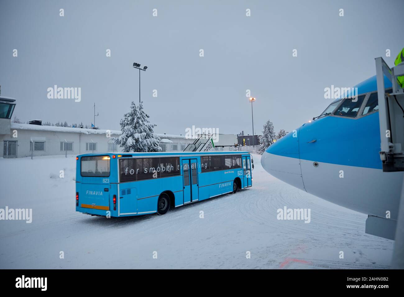 Finnische Rovaniemi eine Stadt in Finnland und der Region Lappland, TUI 737 800 von Boeing auf den verschneiten Flughafen mit vorbeifahrenden Pkw Bus Stockfoto