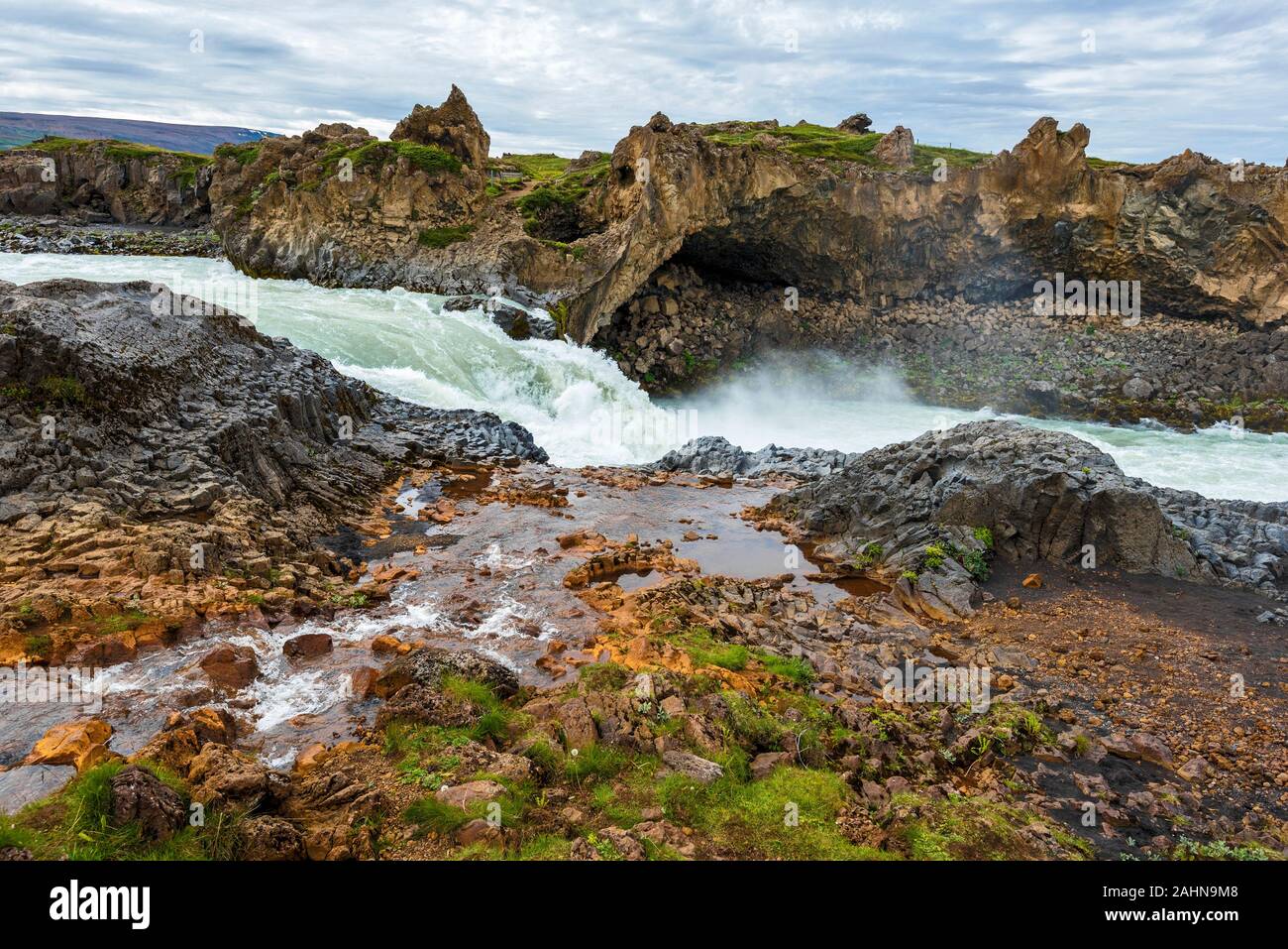 Wasserstrahl freue mich Skjalfandafljot River flussabwärts von Godafoss Wasserfall im Nordosten Islands. Formen und Farben Rocky River Banken machen remarka Stockfoto