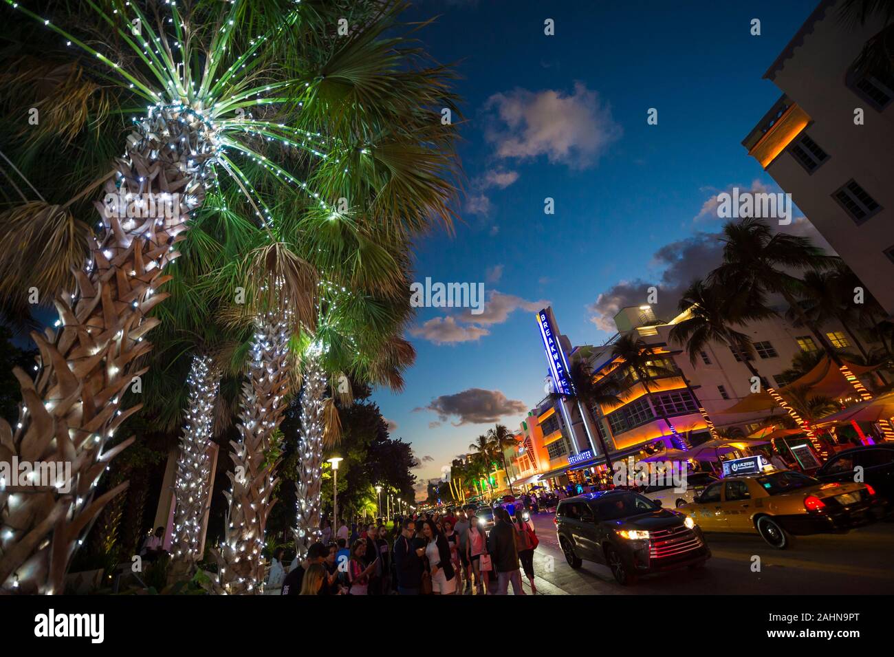 MIAMI - 30. Dezember 2018: die Touristen flanieren Sie die Lichter von Ocean Drive, mit dem Art déco-Neon und Urlaub Palmen mit Lichtern geschmückt Stockfoto