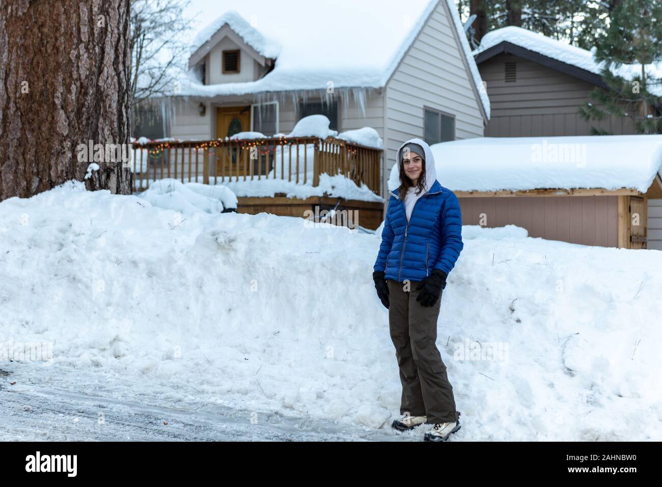 Ziemlich Hausberg Gemeinschaft jugendlicher Mädchen gekleidet warm vor Gepflügt Schnee Bank in ihrer Nachbarschaft Wrightwood home. Stockfoto