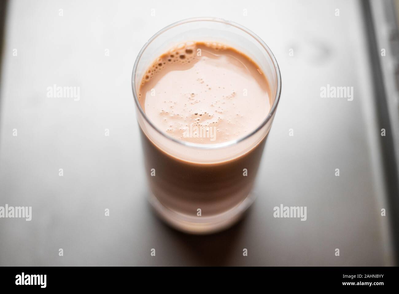 Schokolade Milch in Glas Schale mit grauen verschwommenen Hintergrund Stockfoto