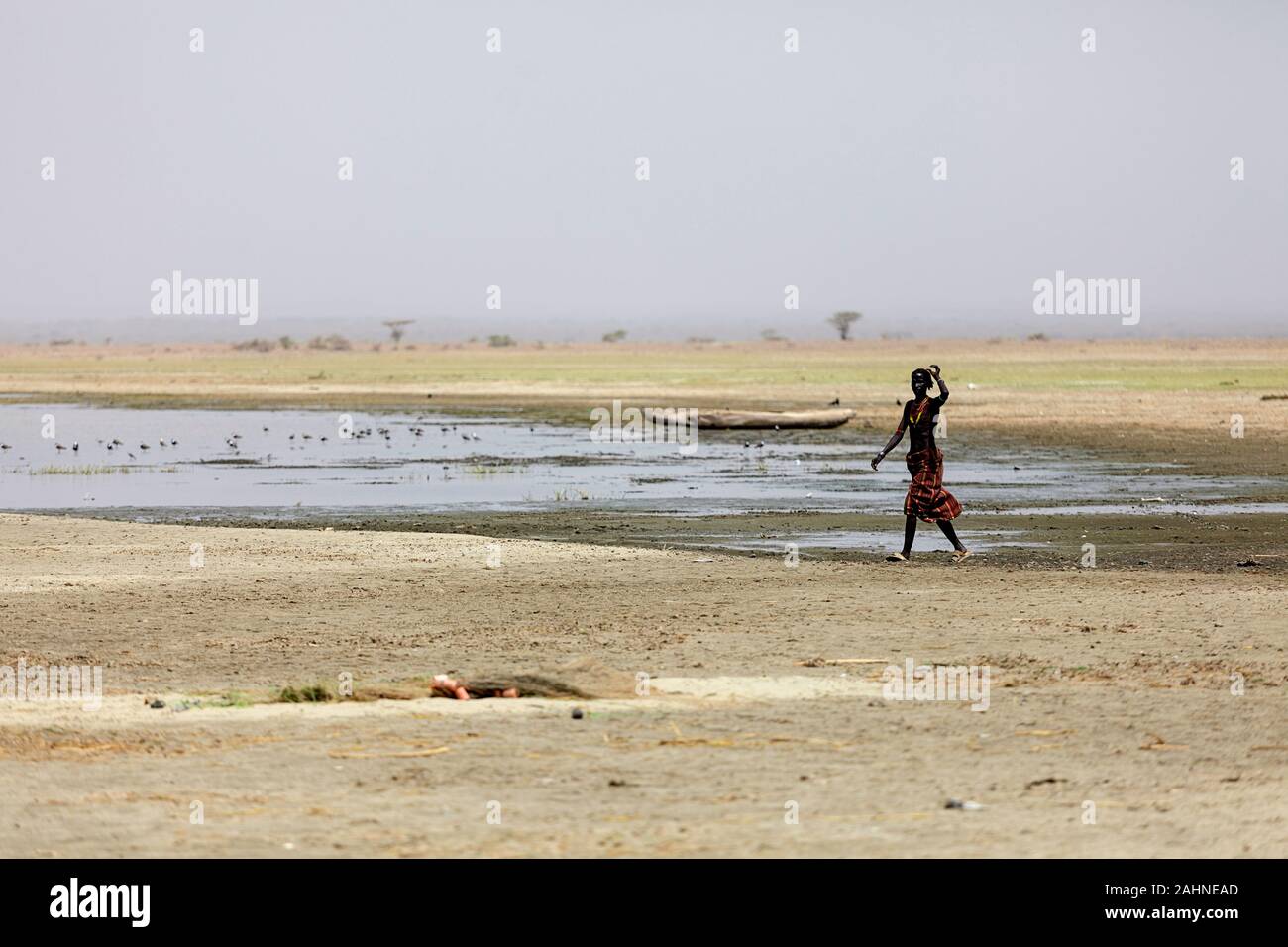 Dassanech-Frau, die am Ufer des Turkana-Sees, der Grenze Äthiopiens und Kenias, spazieren geht Stockfoto