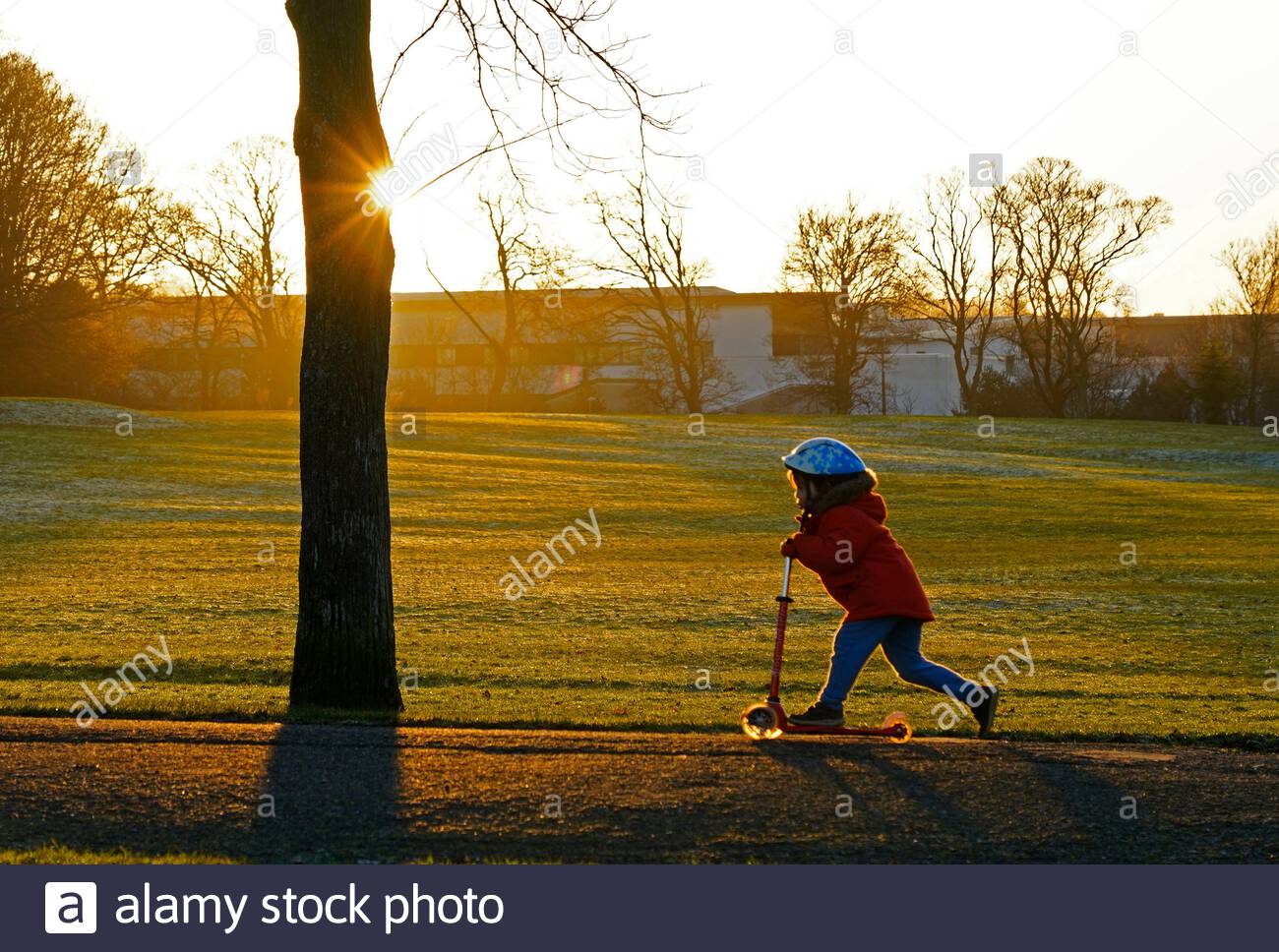 Edinburgh, Schottland, Großbritannien. 31. Dez 2019. Kind auf einem Roller im Freien genießen an einem kalten, klaren und hellen Silvester kurz vor Einsetzen der Dämmerung in Inverleith Park. Quelle: Craig Brown/Alamy leben Nachrichten Stockfoto