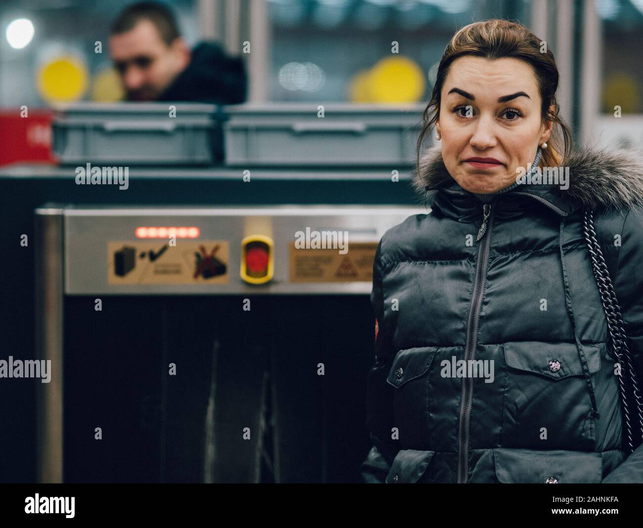 Eine junge Frau schaut in die Kamera. Eine Brünette in demi-Saison Kleidung steht in der Nähe der Sicherheit in der U-Bahn. Im Hintergrund ist ein Stockfoto