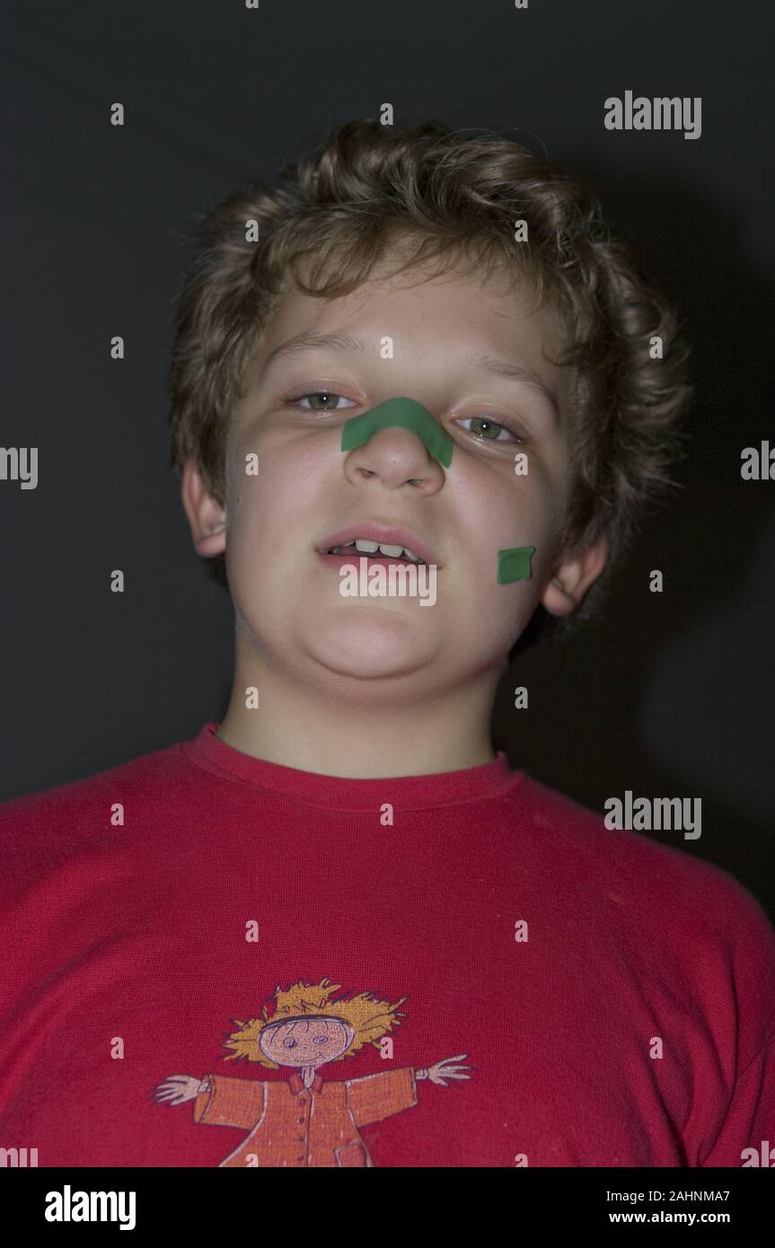 Porträt einer müde Junge mit grünen Flecken auf seinem Gesicht Stockfoto